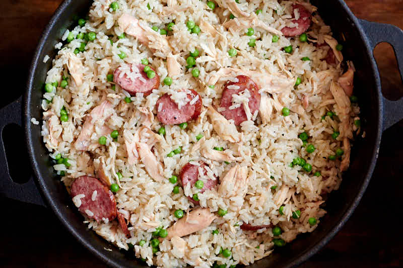 Chicken bog mixed rice, peas, chicken and sausage in a large pot