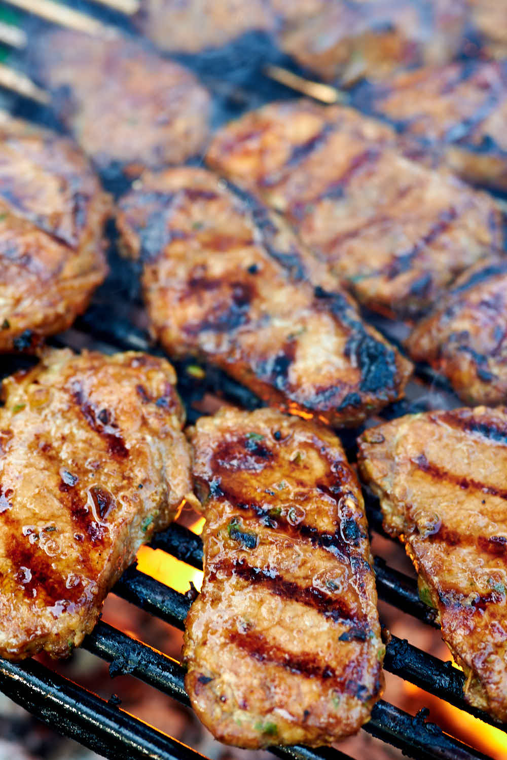 Pork chops grilling on a grill over fire