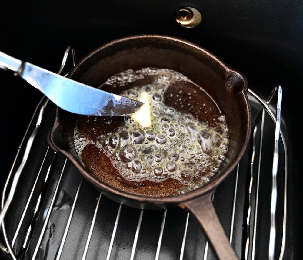 Melting butter inside hot cast iron pan.